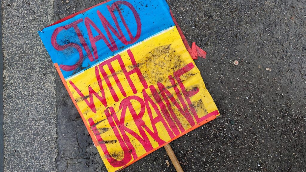 Schild `Stand with Ukraine` liegt auf dem Boden (Archiv)