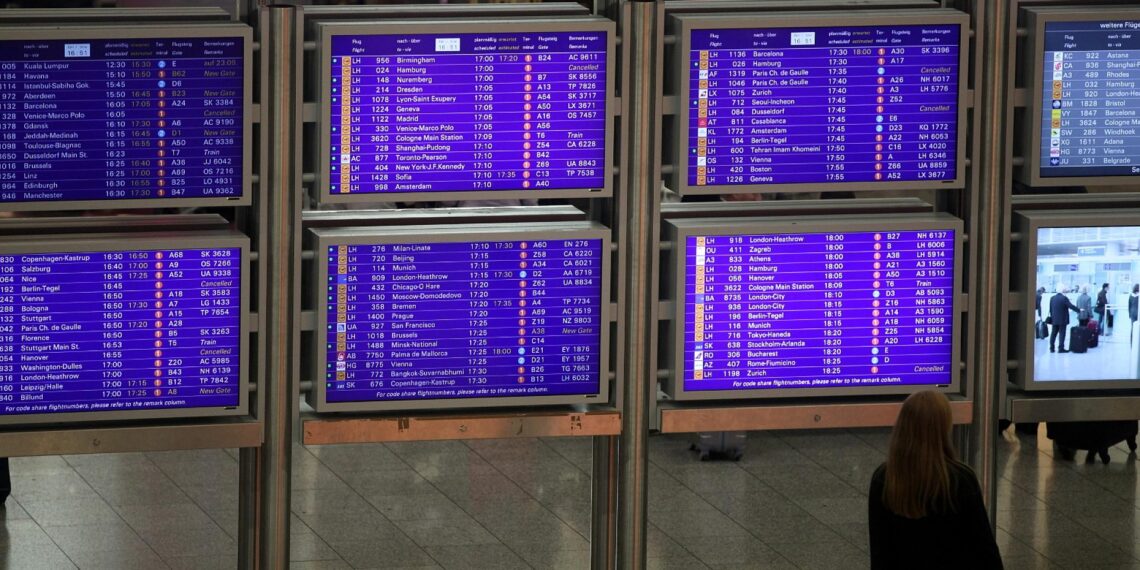 Frau vor Informationstafel am Frankfurter Flughafen