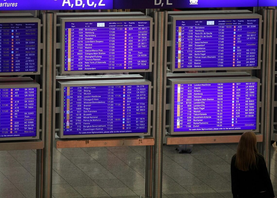 Frau vor Informationstafel am Frankfurter Flughafen