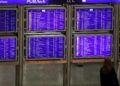 Frau vor Informationstafel am Frankfurter Flughafen