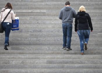 Drei Personen gehen eine Treppe hinauf (Archiv)