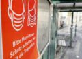 Hinweis auf Mund-Nasen-Schutz an einer Straßenbahnhaltestelle (Archiv)