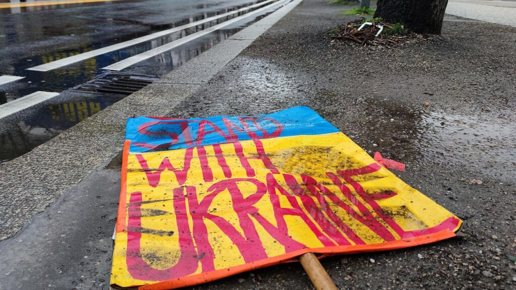 Schild `Stand with Ukraine` liegt auf dem Boden (Archiv)
