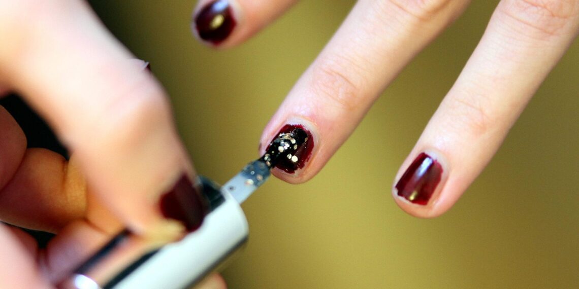 Frau lackiert Fingernägel mit Nagellack (Archiv)
