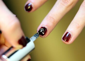 Frau lackiert Fingernägel mit Nagellack (Archiv)