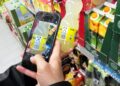 Kunde mit Smartphone im Supermarkt (Archiv)