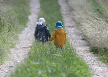 Zwei kleine Kinder laufen auf einem Feldweg (Archiv)