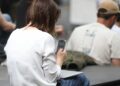 EU-Kommission ermittelt gegen Meta wegen KI-Zugang zu Whatsapp 9 Frau mit Smartphone (Archiv)