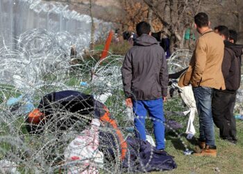 Flüchtlinge auf der Balkanroute vor einem Grenzzaun (Archiv)