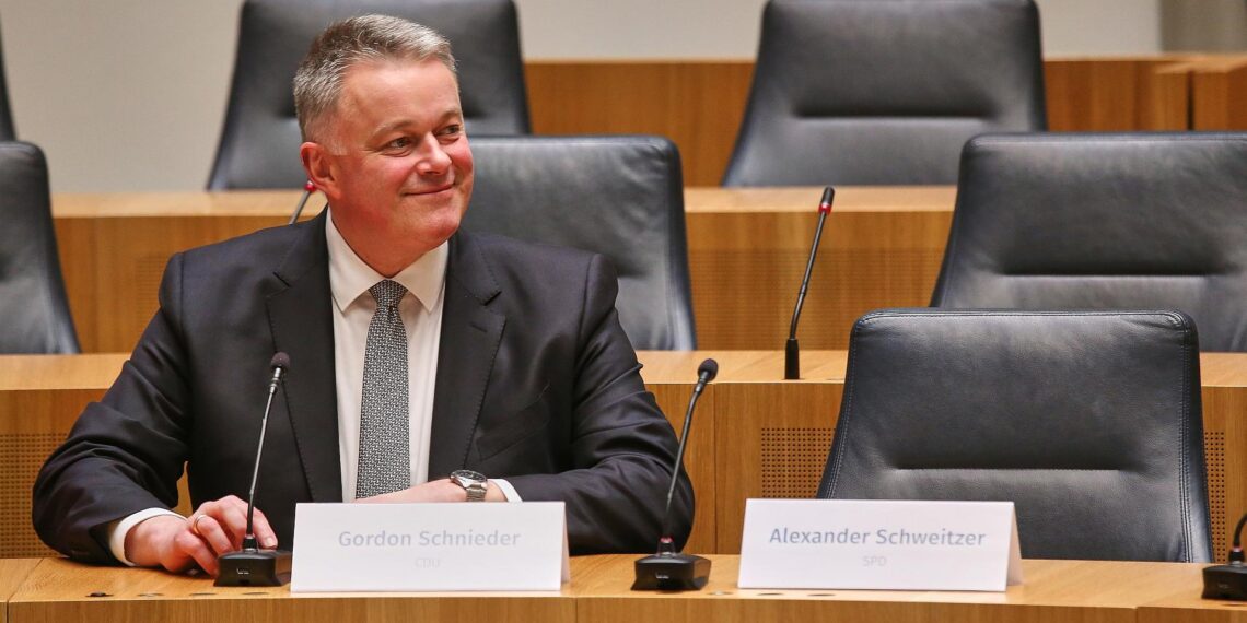 Schweitzer verspricht CDU Bildung einer "ordentlichen Regierung" 1 Gordon Schnieder sitzt neben dem leeren Stuhl von Alexander Schweitzer am 22.03.2026