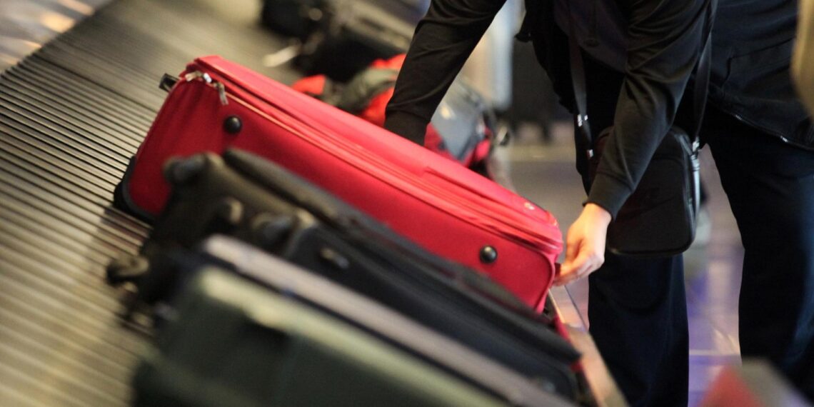 Reisende an einem Gepäckband (Archiv)