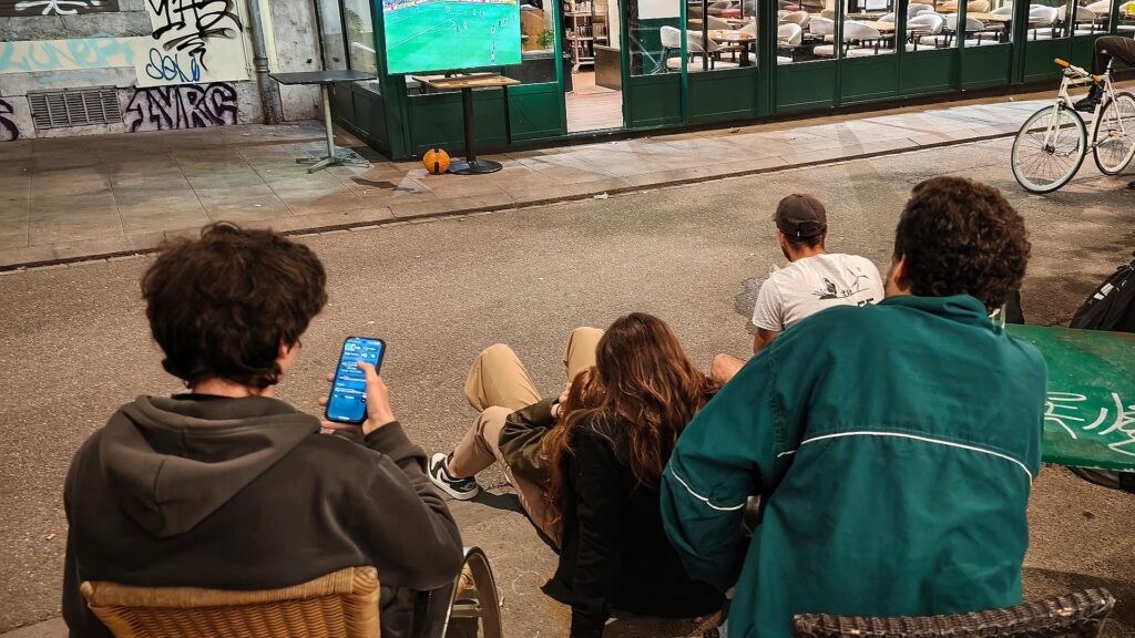 Interessierte schauen nachts auf der Straße Fußball-WM 2026
