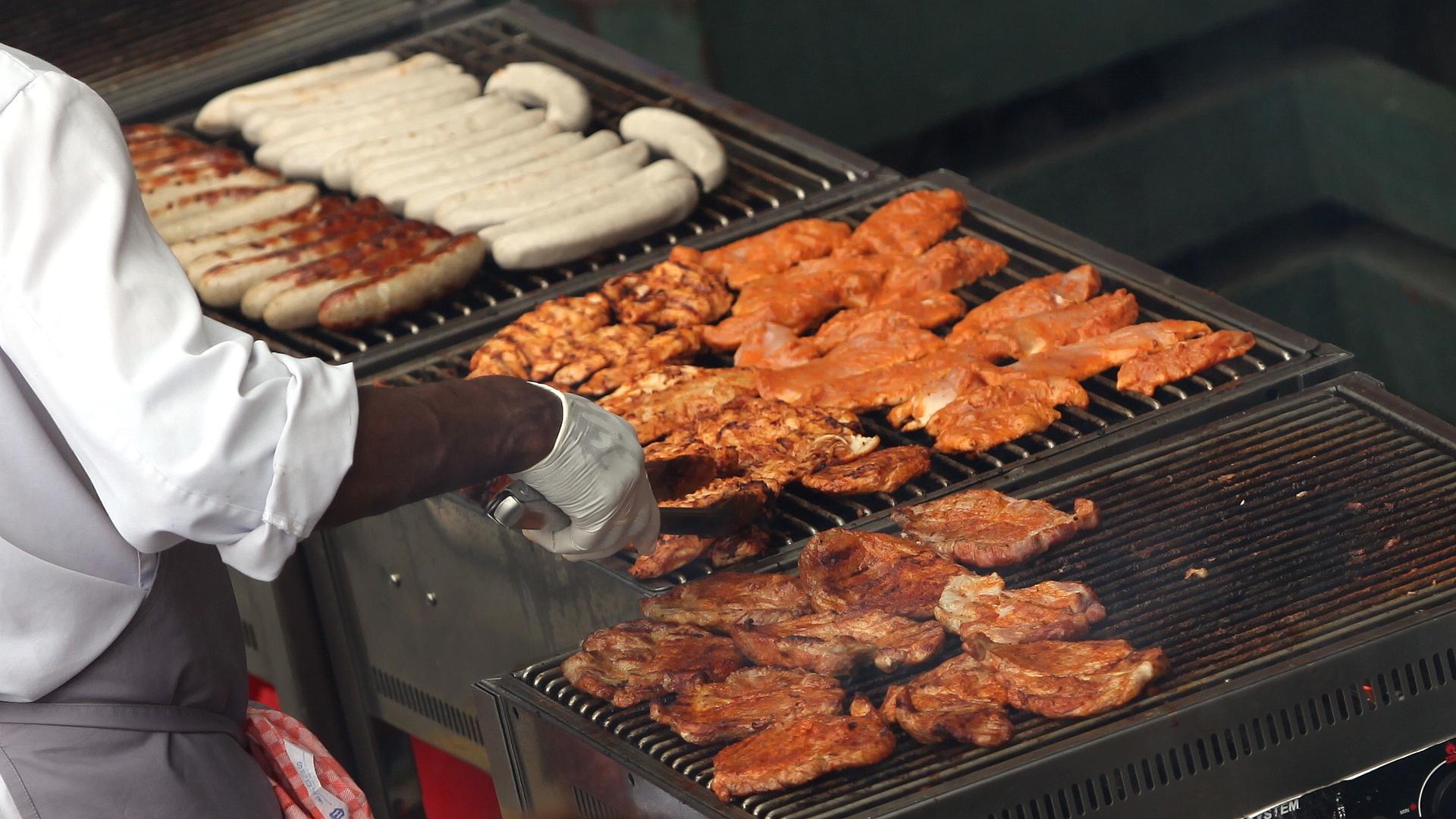 Hähnchenschnitzel und Würste auf einem Grill (Archiv)