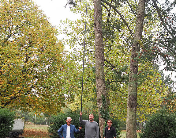 Aktuelles aus Völklingen Drei Personen vor einem hohen Baum mit der Teleskoplanze